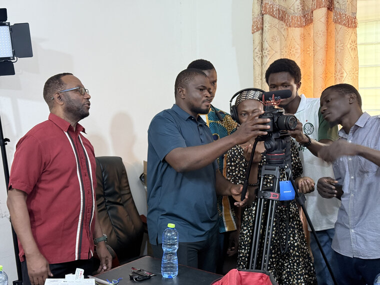 Photo of Participatory Video training leader Ian Boxill, Professor at the University of the West Indies (Mona Campus) and Adjunct Professor at UBIDS, assisting students from the University of Business and Integrated Development Studies (UBIDS) with PV equipment.